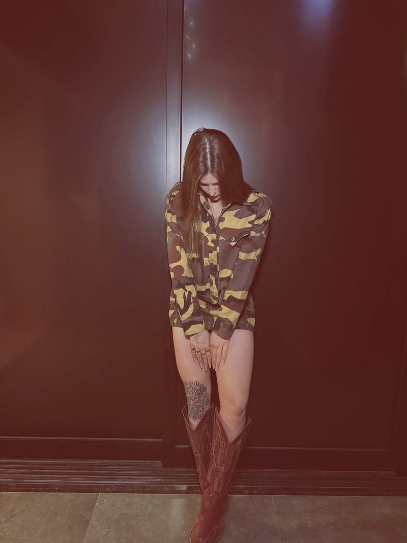 Jaqueta camuflada aberta com botas texanas vermelhas